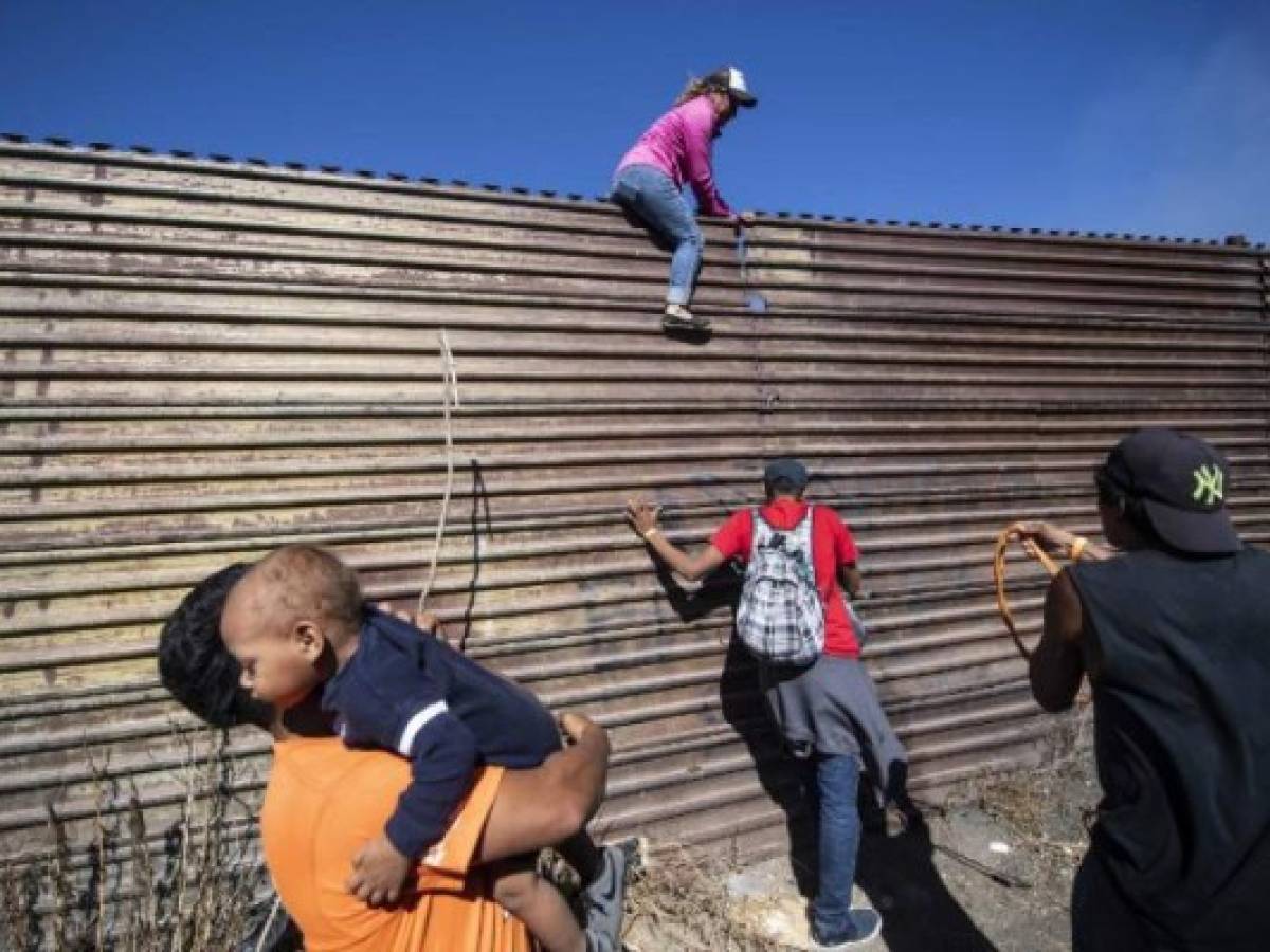 A group of Central American migrants -mostly Hondurans- climb a metal barrier on the Mexico-US border near El Chaparral border crossing, in Tijuana, Baja California State, Mexico, on November 25, 2018. - US officials closed the San Ysidro crossing point in southern California on Sunday after hundreds of migrants, part of the 'caravan' condemned by President Donald Trump, tried to breach a fence from Tijuana, authorities announced. (Photo by Pedro PARDO / AFP) A group of Central American migrants -mostly Hondurans- climb a metal barrier on the Mexico-US border near El Chaparral border crossing, in Tijuana, Baja California State, Mexico, on November 25, 2018. - US officials closed the San Ysidro crossing point in southern California on Sunday after hundreds of migrants, part of the 'caravan' condemned by President Donald Trump, tried to breach a fence from Tijuana, authorities announced. (Photo by Pedro PARDO / AFP)