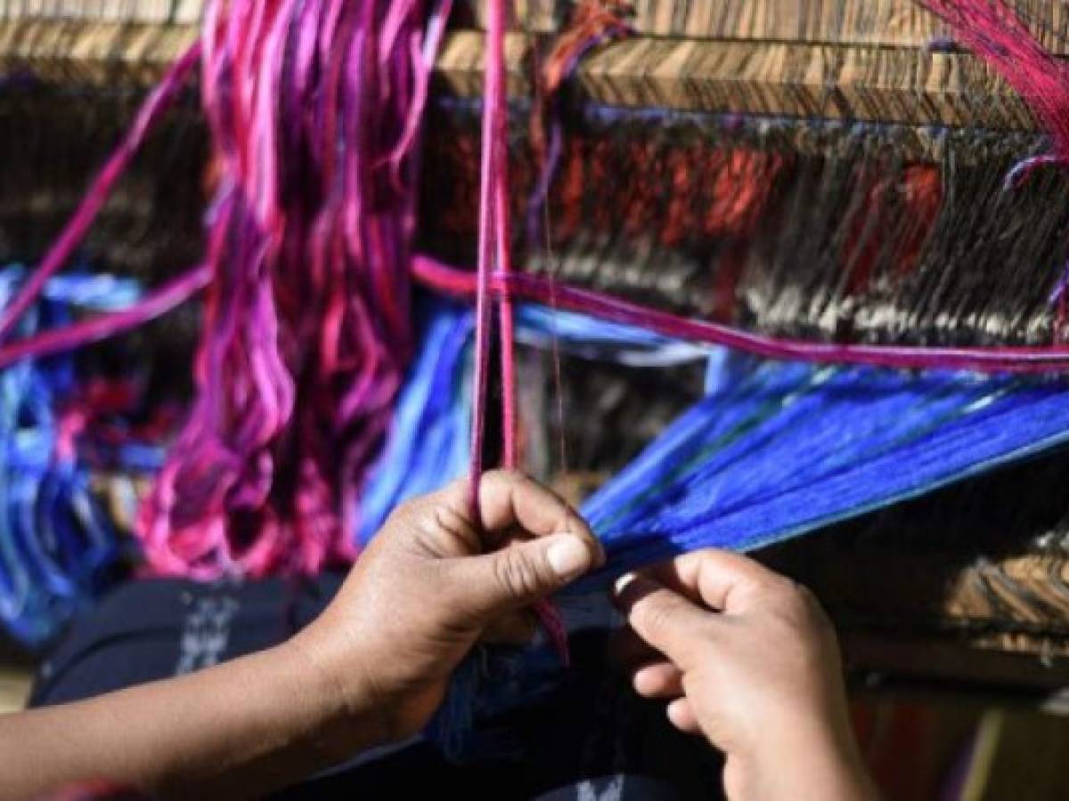 Catarina Tzoc weaves fabric rolls inspired by Mayan costumes for the making of reusable bags, in an attempt to put a curb on the abuse of plastic usage, in Nahuala municipality, Solola departament 85 km west of Guatemala City, on February 16, 2018. / AFP PHOTO / JOHAN ORDONEZ / TO GO WITH AFP STORY by HENRY MORALES ARANA