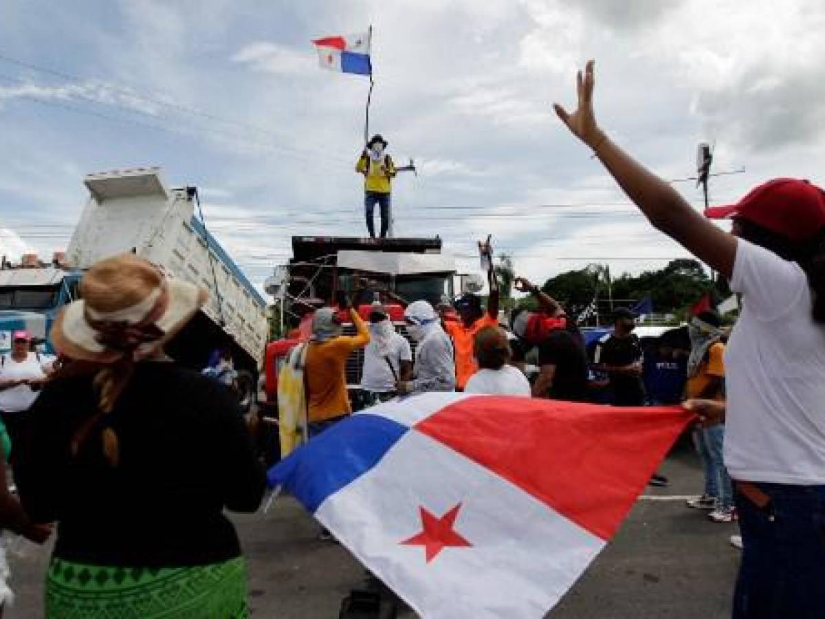 Un hombre ondea una bandera panameña encima de un camión mientras la carretera Panamericana permanece bloqueada en Chame, Panamá, el 14 de julio de 2022. (Foto de ROGELIO FIGUEROA / AFP) Un hombre ondea una bandera panameña encima de un camión mientras la carretera Panamericana permanece bloqueada en Chame, Panamá, el 14 de julio de 2022. (Foto de ROGELIO FIGUEROA / AFP)