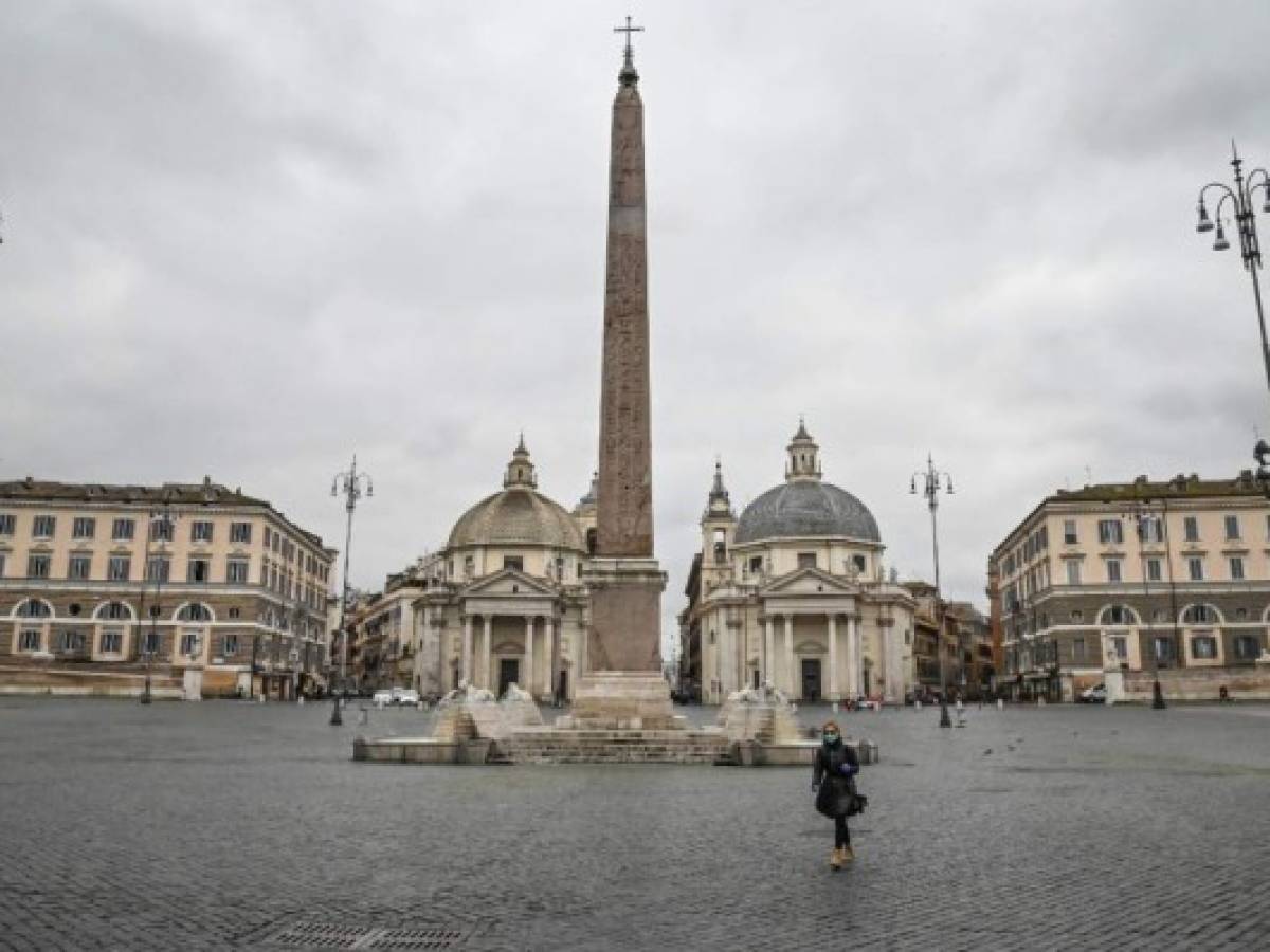 Una persona con máscara respiratoria cruza una desierta Piazza del Popolo en el centro de Roma, Italia. Foto Andreas SOLARO / AFP