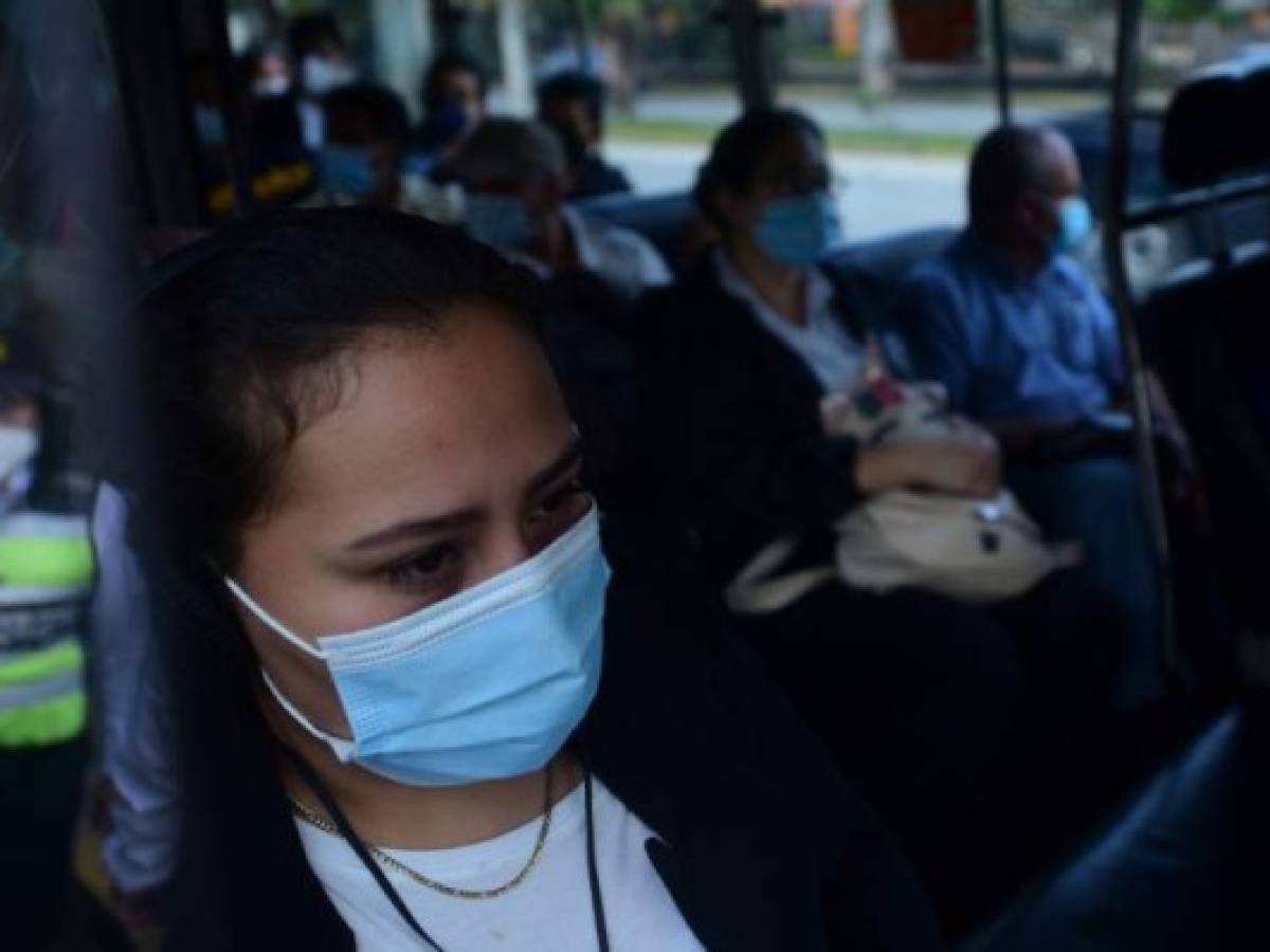 People ride a public bus after the government eased lockdown measures after five months of quarantine to fight the spread of the novel coronavirus COVID-19, in San Salvador on August 24, 2020. (Photo by MARVIN RECINOS / AFP)