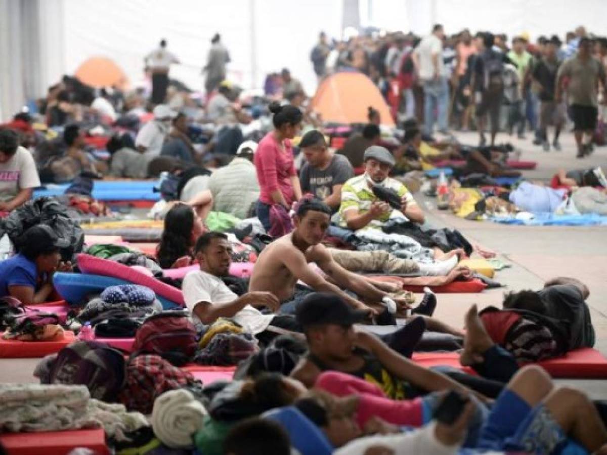 Central American migrants - mostly Hondurans- taking part in a caravan heading to the US, rest at a temporary shelter, set up in a stadium in Mexico City, during a stop in their journey, on November 05, 2018. - Some 2,000 migrants en route to US recover energy Monday in a shelter in Mexico City, where they await the arrival of thousands more. US President Donald Trump warned that up to 15,000 soldiers could be deployed in the border with Mexico to stop the migrants' attempt to cross illegally into the country. (Photo by Alfredo ESTRELLA / AFP)