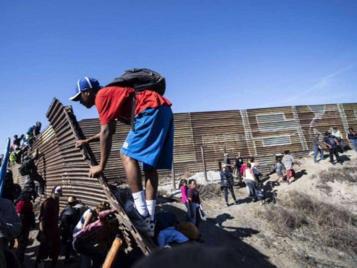Cientos de migrantes tratan de saltar la valla fronteriza entre México y EEUU