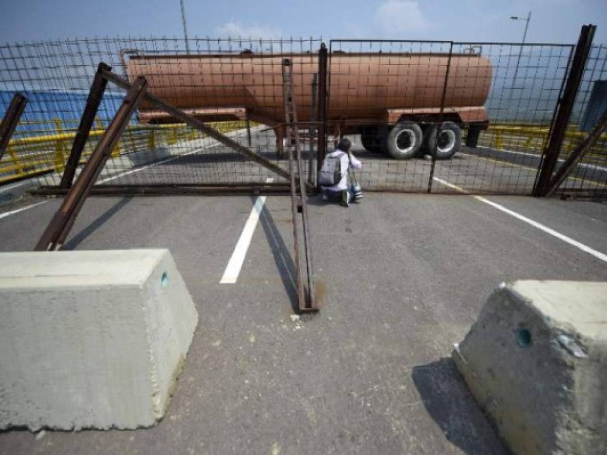 A photographer takes a picture as Venezuelan military forces block with containers the Tienditas Bridge, which links Tachira, Venezuela, and Cucuta, Colombia, on February 6, 2019. - Venezuelan military officers blocked a bridge on the border with Colombia ahead of an anticipated humanitarian aid shipment, as opposition leader Juan Guaido stepped up his challenge to President Nicolas Maduro's authority. (Photo by Raul Arboleda / AFP)