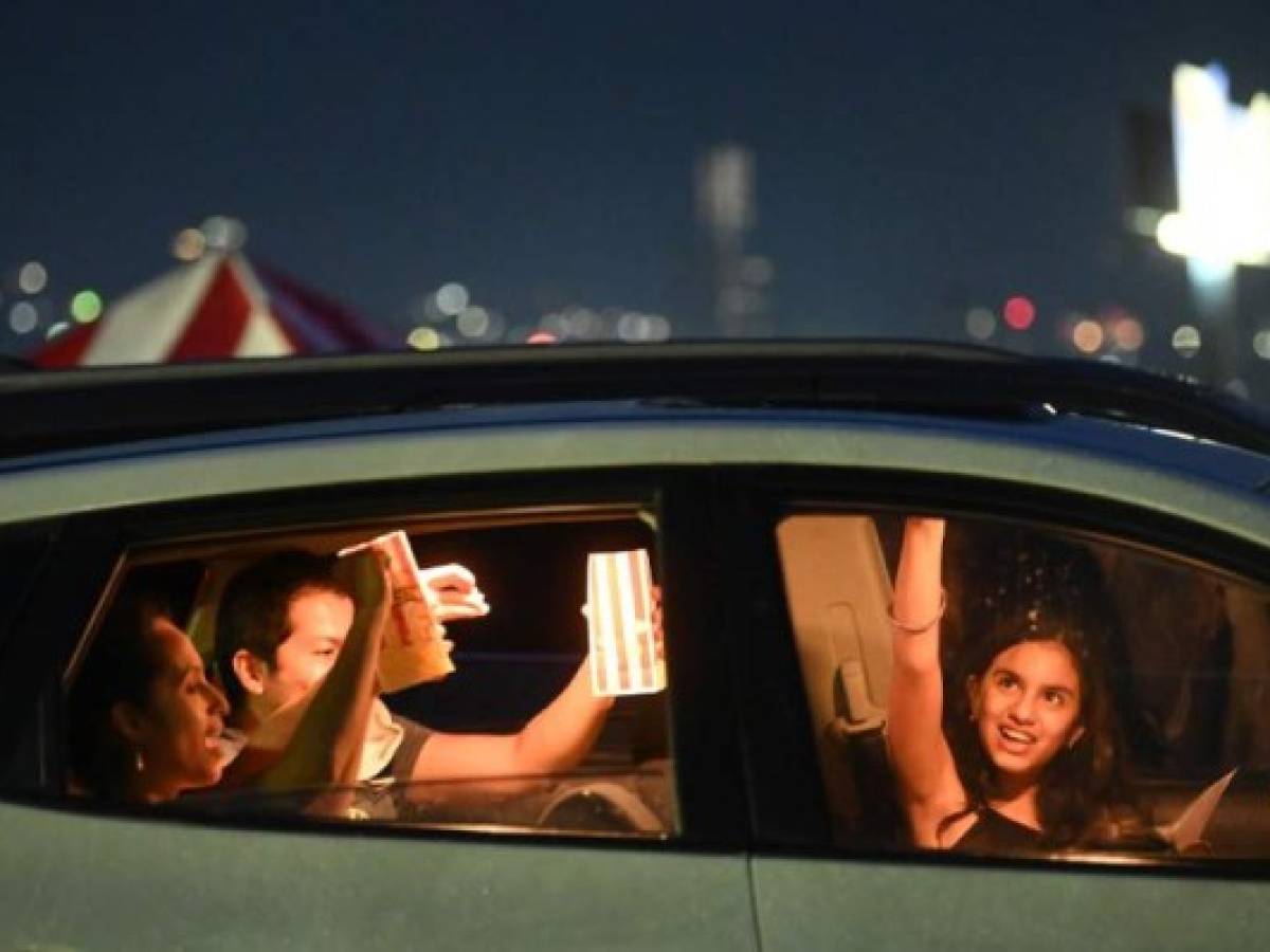 People sit in their cars to watch a movie in a drive-in cinema in San Salvador, on August 5, 2020, amid the novel coronavirus pandemic. (Photo by MARVIN RECINOS / AFP)