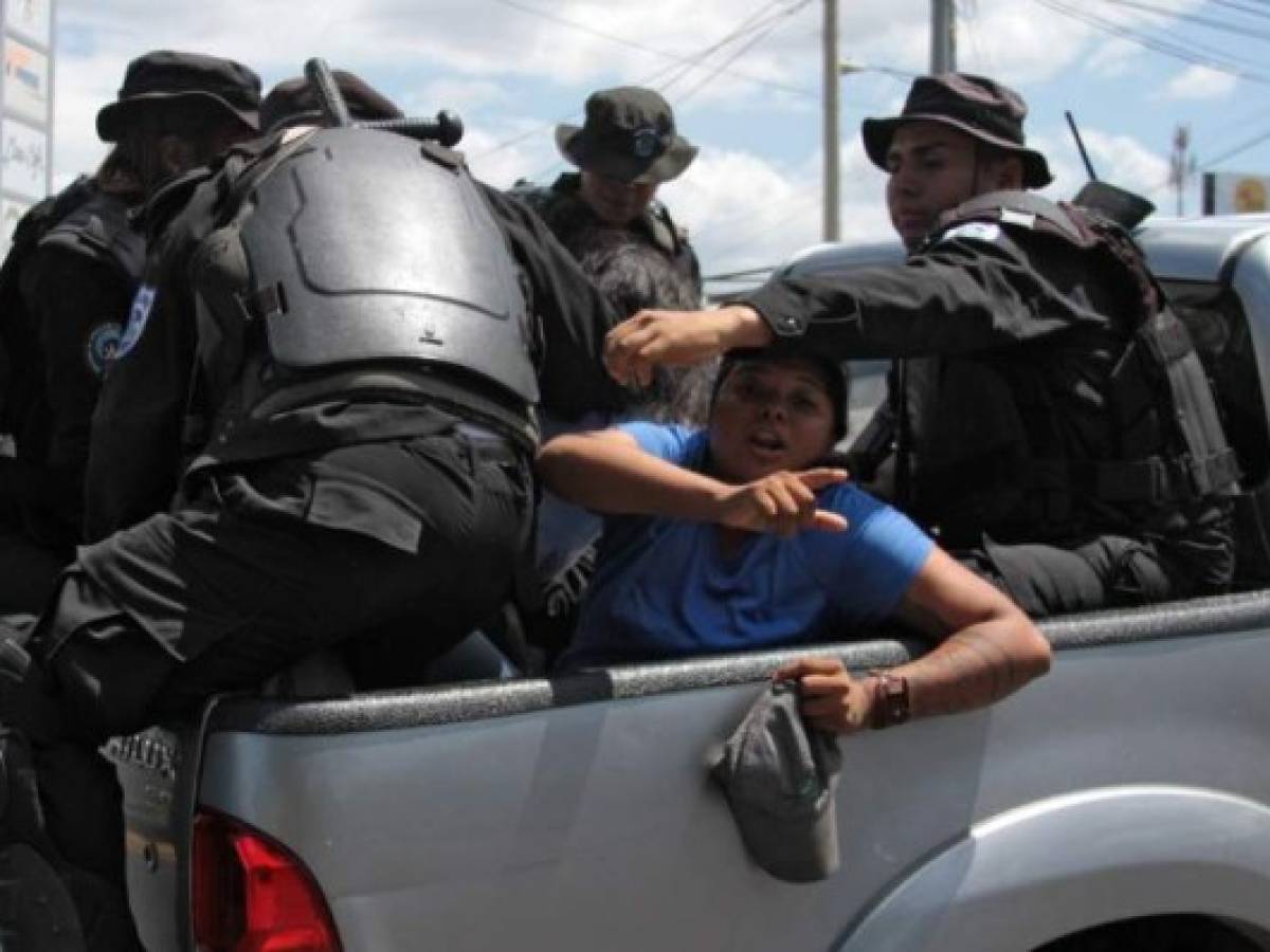 Nicaraguan riot police officers leave with two people arrested while their were heading to a demonstration called by opposition groups to demand the government the release of those arrested for taking part in anti-government protests, in Managua on March 16, 2019. - Nicaragua on Friday released 50 prisoners held for participating in anti-government protests, giving a fresh impetus to peace talks on ending the country's long running political crisis. More than 700 people were detained during a deadly crackdown on rallies that began last April and quickly grew into broad opposition to President Daniel Ortega iron-fisted rule. (Photo by Maynor Valenzuela / AFP)