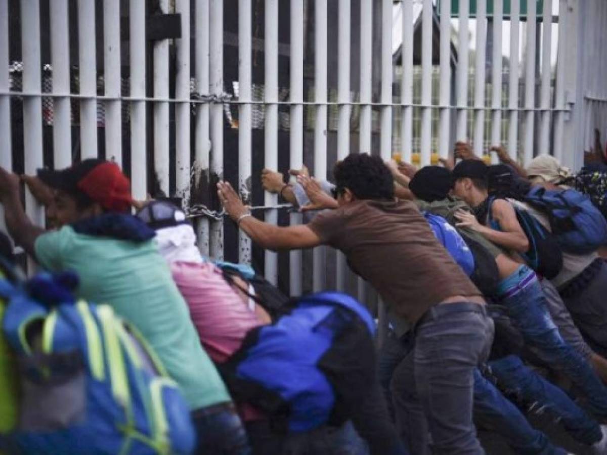 Honduran migrants taking part in a caravan heading to the US, tear down the border fence between Ciudad Tecun Uman in Guatemala and Ciudad Hidalgo, Mexico, on October 28, 2018. - A new group of Honduran migrants is trying to reach and cross the Guatemalan border into Mexico in the hope of eventually realizing the 'American dream' and reaching the United States. (Photo by SANTIAGO BILLY / AFP) Honduran migrants taking part in a caravan heading to the US, tear down the border fence between Ciudad Tecun Uman in Guatemala and Ciudad Hidalgo, Mexico, on October 28, 2018. - A new group of Honduran migrants is trying to reach and cross the Guatemalan border into Mexico in the hope of eventually realizing the 'American dream' and reaching the United States. (Photo by SANTIAGO BILLY / AFP)