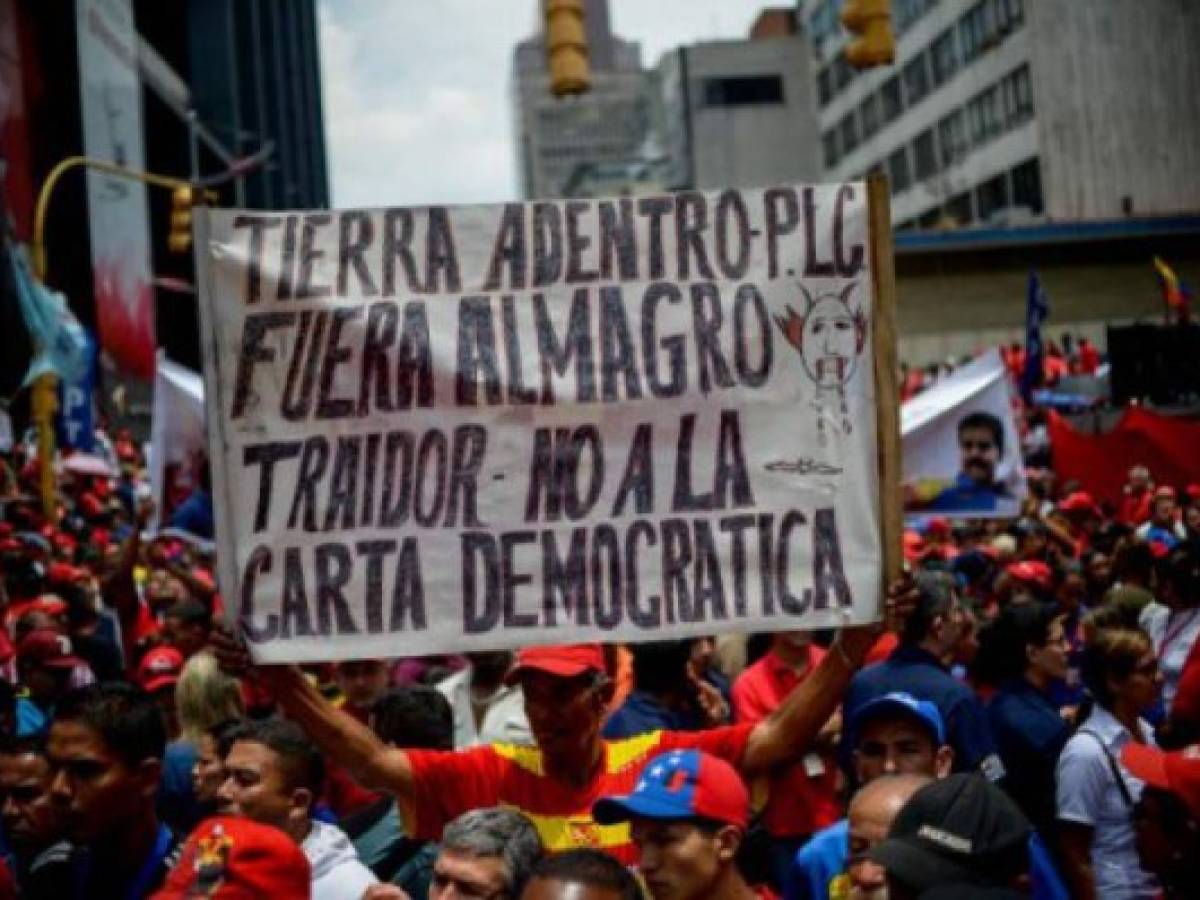 Supporters of Venezuelan President Nicolas Maduro take part in a rally against the secretary general of the Organization of American States (OAS), Luis Almagro, in Caracas on March 28, 2017. / AFP PHOTO / FEDERICO PARRA