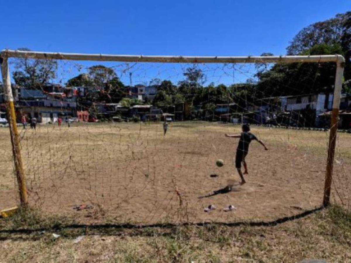 Children play football in El Erizo neighbourhood, in the province of Alajuela, Costa Rica, on January 4, 2022. - Costa Rica, one of the most stable democracies in Latin America, which will elect its president on February 6, has been affected by poverty. According to the Community of Latin American and Caribbean States (CELAC), it is one of the countries in the region, along with Brazil, where more people will fall into poverty, due to the cutback of government aid and the effects of the pandemic. (Photo by Luis ACOSTA / AFP) / TO GO WHIT AFP STORY BY DAVID GOLDBERG Children play football in El Erizo neighbourhood, in the province of Alajuela, Costa Rica, on January 4, 2022. - Costa Rica, one of the most stable democracies in Latin America, which will elect its president on February 6, has been affected by poverty. According to the Community of Latin American and Caribbean States (CELAC), it is one of the countries in the region, along with Brazil, where more people will fall into poverty, due to the cutback of government aid and the effects of the pandemic. (Photo by Luis ACOSTA / AFP) / TO GO WHIT AFP STORY BY DAVID GOLDBERG