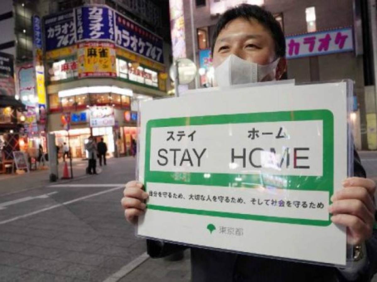 A Tokyo Metropolitan Government official calls for self-restraint to prevent the spread of the new COVID-19 coronavirus at Tokyo's entertainment district Kabukicho on April 10. 2020. - Tokyo Governor Yuriko Koike said on April 10 that the metropolitan government will request many businesses, including night clubs, karaoke parlors and pachinko pinball parlors to suspend operations from April 11 in light of the state of emergency over the coronavirus epidemic. (Photo by STR / JIJI PRESS / AFP) / Japan OUT