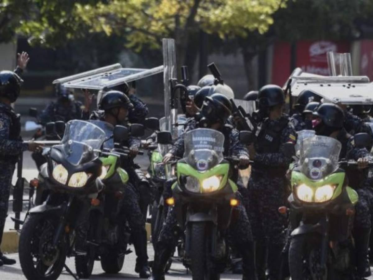 Riot police are deployed during an opposition protest against the government of President Nicolas Maduro on the anniversary of the 1958 uprising that overthrew a military dictatorship, in Caracas on January 23, 2019. - Venezuela's National Assembly head Juan Guaido declared himself the country's 'acting president' on Wednesday during a mass opposition rally against leader Nicolas Maduro. (Photo by Federico Parra / AFP)
