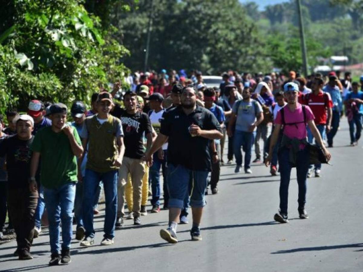 Honduran migrants walk to Puerto Barrios, in Izabal department, Guatemala, after breaking a police fence at the border crossing between Corinto, Honduras and Guatemala, on January 15, 2020. - Some 1,000 Hondurans started a new caravan from San Pedro Sula, in the north of Honduras, to the US, in search of the 'American dream' and fleeing unemployment and violence. At least 30,000 Honduran migrants of the first caravans remain in Mexico waiting for US asylum. (Photo by ORLANDO SIERRA / AFP)