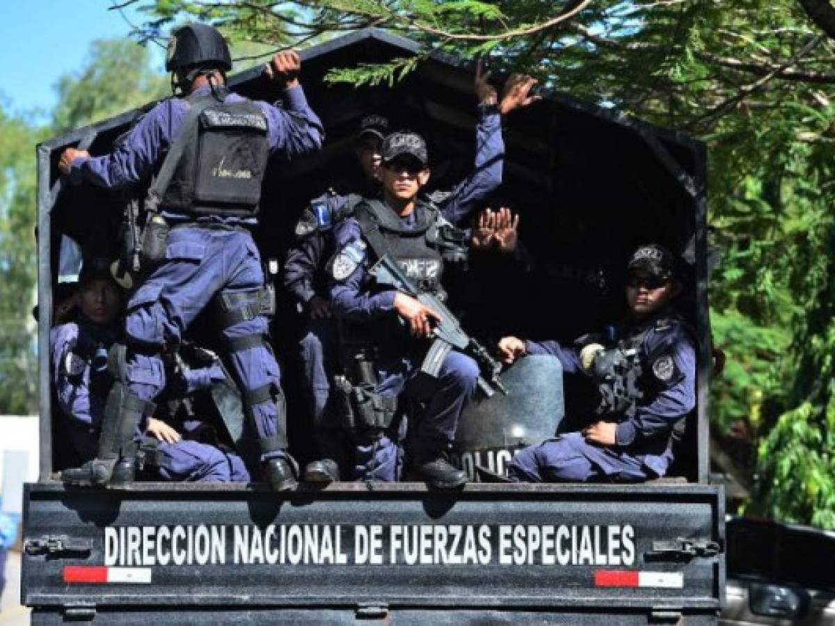 Los migrantes caminaban por la carretera asfaltada al borde del mar Caribe mientras policías y militares los seguían de cerca en vehículos y retenes.