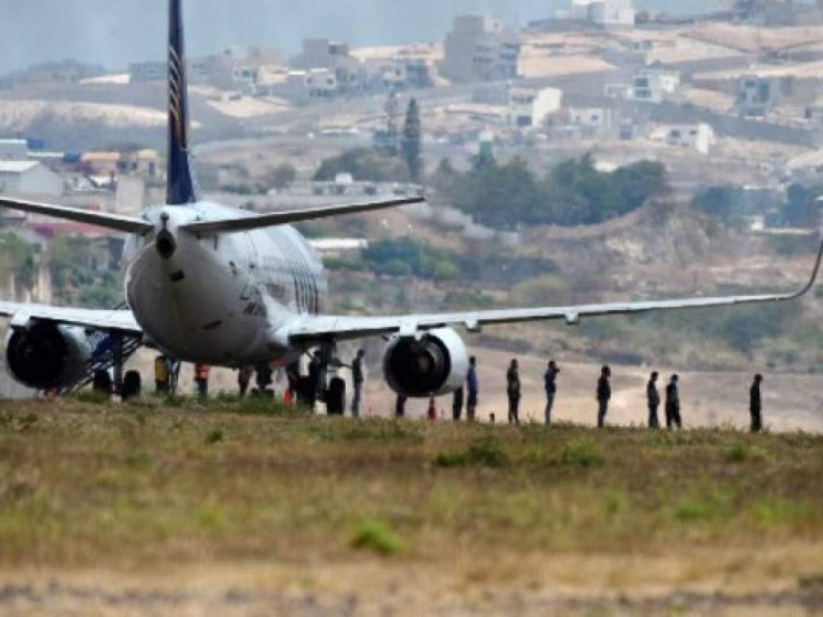 136 migrantes hondureños descienden de un avión en el Aeropuerto Internacional Toncontín en Tegucigalpa el 25 de abril 2020 después de haber sigo deportados de México (Foto ORLANDO SIERRA / AFP)