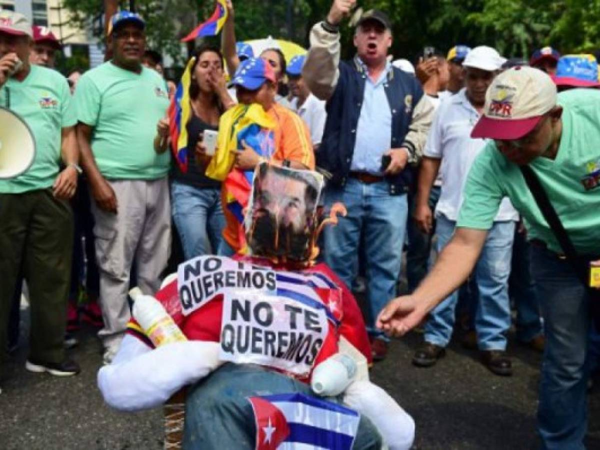 Demonstrators burn an effigy of President Nicolas Maduro during a protest at the east side of Caracas on April 19, 2017.Venezuela braced for rival demonstrations Wednesday for and against President Nicolas Maduro, whose push to tighten his grip on power has triggered waves of deadly unrest that have escalated the country's political and economic crisis. / AFP PHOTO / RONALDO SCHEMIDT