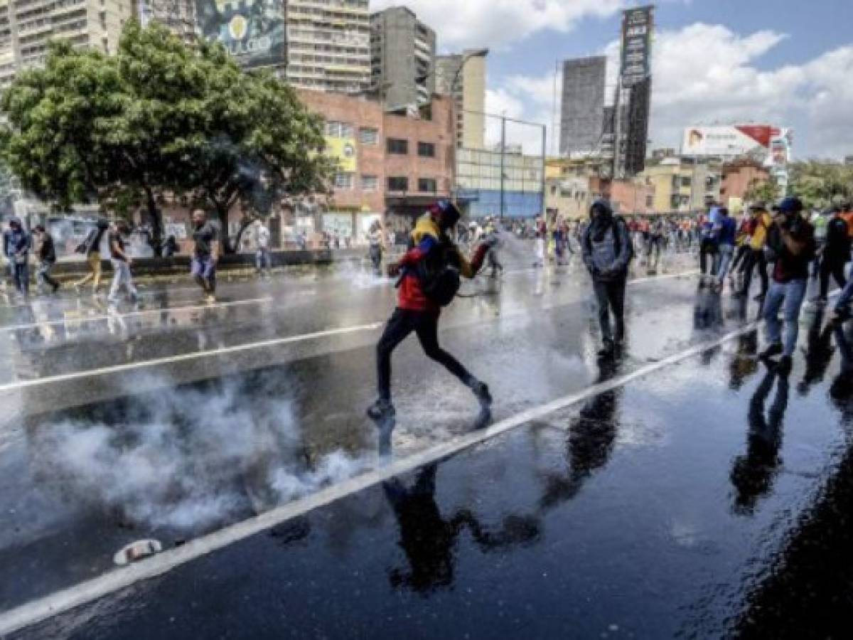 Venezuelan opposition activists clash with the police during a protest against the government of President Nicolas Maduro on April 6, 2017 in Caracas.Violence erupted for a third straight day at protests against the government, escalating tension over moves to keep the leftist leader in power. / AFP PHOTO / JUAN BARRETO