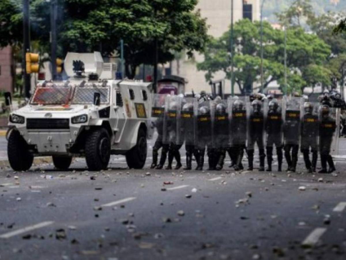 Members of the National Guard crack down on opposition demonstrators during a march against President Nicolas Maduro, in Caracas on April 26, 2017. Venezuelan riot police fired tear gas to stop anti-government protesters from marching on central Caracas, the latest clash in a wave of unrest that, up to now, has left 26 people dead. / AFP PHOTO / FEDERICO PARRA Members of the National Guard crack down on opposition demonstrators during a march against President Nicolas Maduro, in Caracas on April 26, 2017. Venezuelan riot police fired tear gas to stop anti-government protesters from marching on central Caracas, the latest clash in a wave of unrest that, up to now, has left 26 people dead. / AFP PHOTO / FEDERICO PARRA