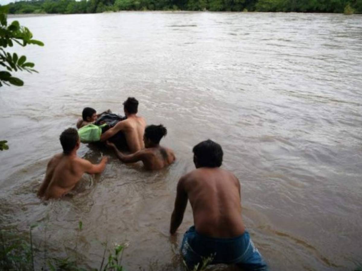 Honduran migrants attempt to cross the border Goascoran River to enter illegally to El Salvador, in Goascoran, Honduras on October 18, 2018. - US President Donald Trump threatened Thursday to send the military to close its southern border if Mexico fails to stem the 'onslaught' of migrants from Central America, in a series of tweets that blamed Democrats ahead of the midterm elections. (Photo by MARVIN RECINOS / AFP)