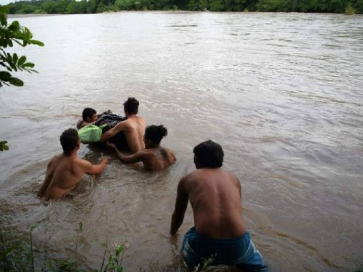 Honduran migrants attempt to cross the border Goascoran River to enter illegally to El Salvador, in Goascoran, Honduras on October 18, 2018. - US President Donald Trump threatened Thursday to send the military to close its southern border if Mexico fails to stem the 'onslaught' of migrants from Central America, in a series of tweets that blamed Democrats ahead of the midterm elections. (Photo by MARVIN RECINOS / AFP) Honduran migrants attempt to cross the border Goascoran River to enter illegally to El Salvador, in Goascoran, Honduras on October 18, 2018. - US President Donald Trump threatened Thursday to send the military to close its southern border if Mexico fails to stem the 'onslaught' of migrants from Central America, in a series of tweets that blamed Democrats ahead of the midterm elections. (Photo by MARVIN RECINOS / AFP)