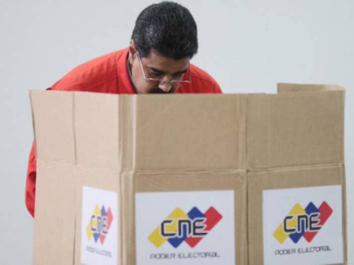 Handout photo released by the Venezuelan Presidency shows president Nicolas Maduro casting his vote in Caracas on July 30, 2017. Polls opened in Venezuela on Sunday for the election of a new, all-powerful 'Constituent Assembly' that President Nicolas Maduro promised would end his country's political and economic crisis by rewriting the constitution.The vote has been fiercely opposed by months of deadly street protests and criticized internationally. Venezuela's opposition says it is a bid for the beleaguered Maduro to cling to power by getting around the parliament controlled by its lawmakers. / AFP PHOTO / PRESIDENCIA / RESTRICTED TO EDITORIAL USE - MANDATORY CREDIT 'AFP PHOTO / PIB' - NO MARKETING NO ADVERTISING CAMPAIGNS - DISTRIBUTED AS A SERVICE TO CLIENTS Handout photo released by the Venezuelan Presidency shows president Nicolas Maduro casting his vote in Caracas on July 30, 2017. Polls opened in Venezuela on Sunday for the election of a new, all-powerful 'Constituent Assembly' that President Nicolas Maduro promised would end his country's political and economic crisis by rewriting the constitution.The vote has been fiercely opposed by months of deadly street protests and criticized internationally. Venezuela's opposition says it is a bid for the beleaguered Maduro to cling to power by getting around the parliament controlled by its lawmakers. / AFP PHOTO / PRESIDENCIA / RESTRICTED TO EDITORIAL USE - MANDATORY CREDIT 'AFP PHOTO / PIB' - NO MARKETING NO ADVERTISING CAMPAIGNS - DISTRIBUTED AS A SERVICE TO CLIENTS