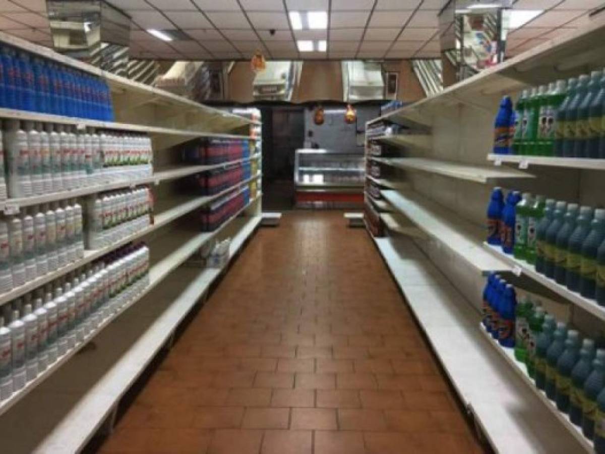 View of partially empty supermarket shelves in Caracas on January 6, 2018. Venezuela's government forced more that 200 establishments to lower prices in the middle of a hyperinflationary spiral. / AFP PHOTO / JUAN BARRETO
