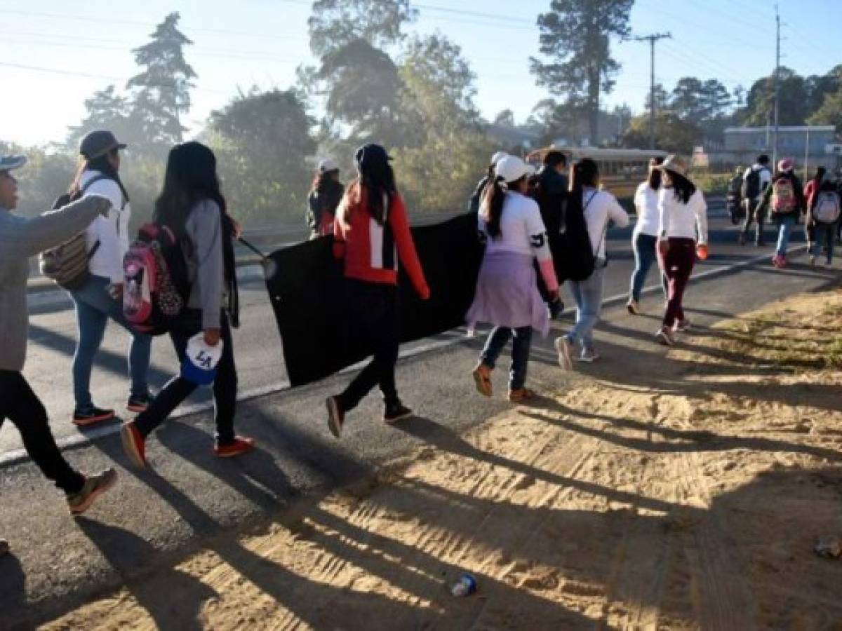 A group girls take part in a 41-km march to remember and demand justice on the eve of the first anniversary of a fire at a children's shelter in San Jose Pinula, close to the capital, that left 41 girls dead and 15 wounded, in the municipality of Sumpango, Sacatepequez Departament, west of Guatemala City on March 7, 2018. / AFP PHOTO / Johan ORDONEZ