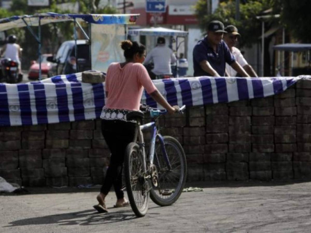 Una mujer pasa junto a una barricada en Sebaco, en Managua. AFP PHOTO / Inti Ocon