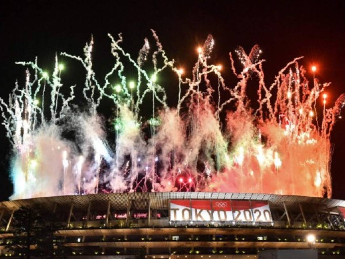 Los fuegos artificiales estallan alrededor del Estadio Olímpico durante la ceremonia de clausura de los Juegos Olímpicos de Tokio 2020, visto desde fuera de la sede en Tokio el 8 de agosto de 2021 (Foto de Kazuhiro NOGI / AFP).