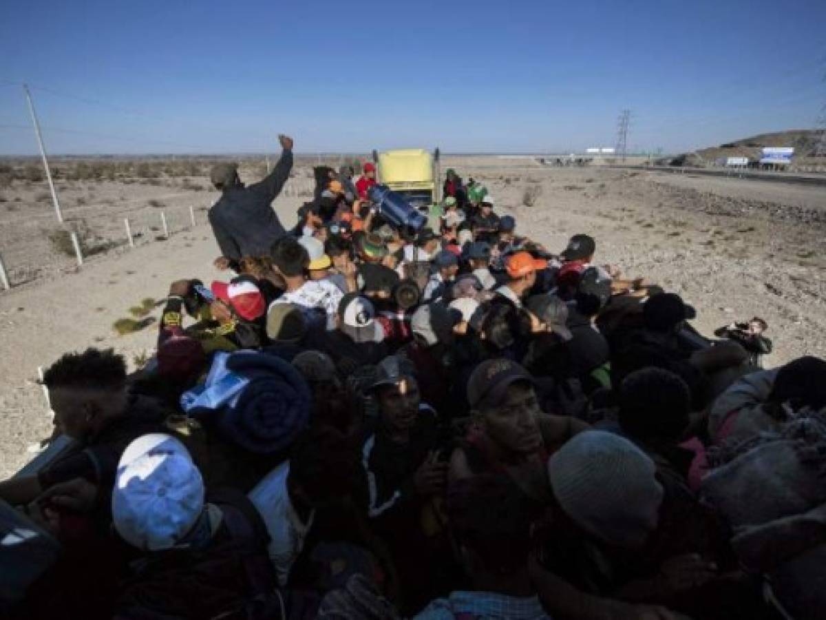 Central American migrants -mostly Hondurans- moving in a caravan towards the United States in hopes of a better life, head to Tijuana in Mexico's Baja California State, after leaving Mexicali on November 19, 2018. - US President Trump has sent about 5,800 troops to the border to forestall the arrival of large groups of Central American migrants travelling through Mexico and towards the US, in a move critics decry as a costly political stunt to galvanize supporters ahead of midterm elections earlier this month. (Photo by PEDRO PARDO / AFP)