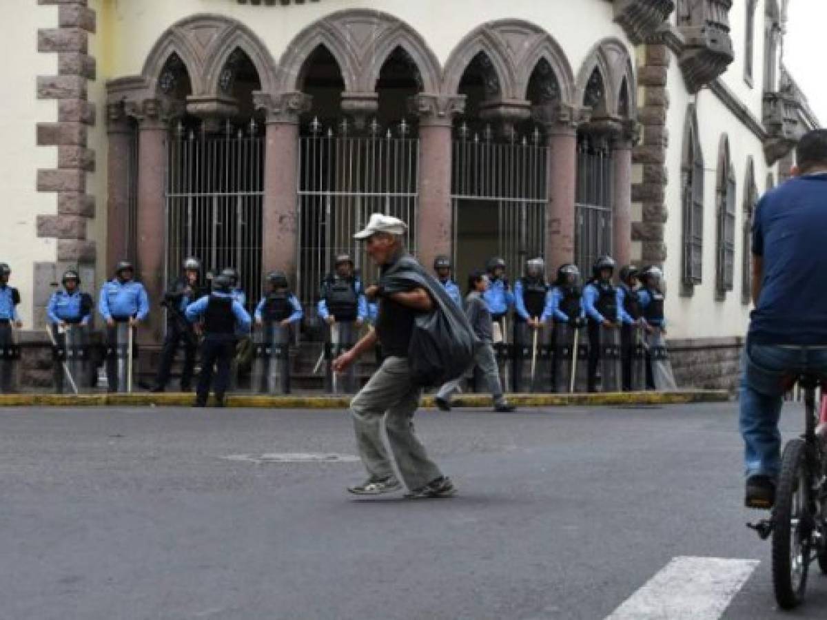 Riot police stand guard outside the former presidential palace in the surroundings of the Tiburcio Carias Andino national stadium, where Honduran relected president Juan Orlando Hernandez will inaugurate his second term, in Tegucigalpa, on January 26, 2018. Hernandez is preparing to begin his second presidential term Saturday after winning November's disputed vote. / AFP PHOTO / ORLANDO SIERRA