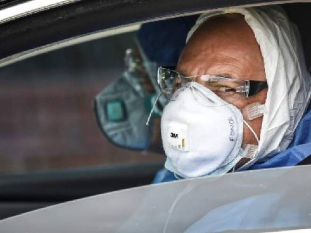 Cemetery workers wear protective suits as a preventive measure against the spread of the new coronavirus, COVID-19, in Bogota on April 12, 2020. - Latin America and the Caribbean accounted for more than 61,000 COVID-19 infections on Sunday, with more than 2,500 deaths, according to an AFP balance prepared with information from national authorities and the World Health Organization (WHO). (Photo by Juan BARRETO / AFP)