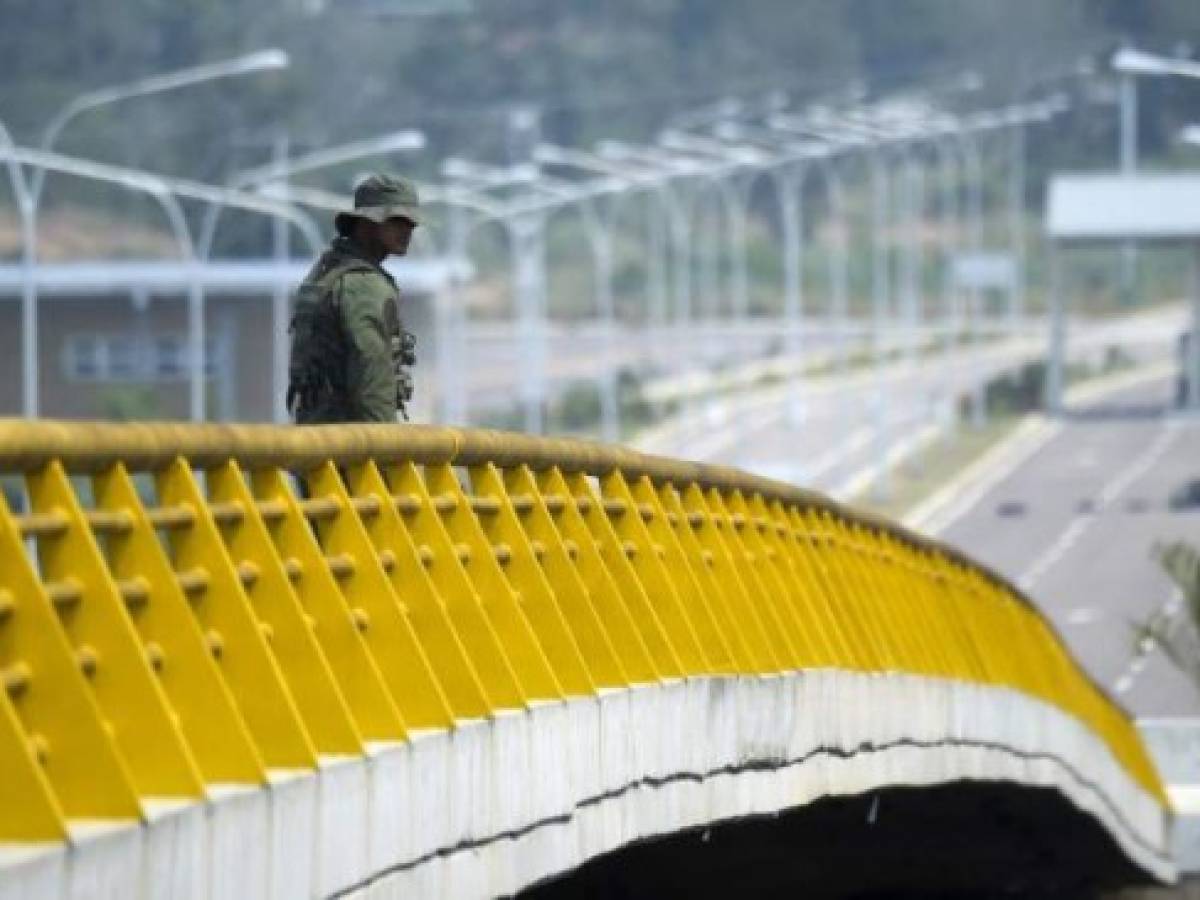 A Venezuelan military officer stands guard as containers block the Tienditas Bridge, which links Tachira, Venezuela, and Cucuta, Colombia, on February 6, 2019. - Venezuelan military officers blocked a bridge on the border with Colombia ahead of an anticipated humanitarian aid shipment, as opposition leader Juan Guaido stepped up his challenge to President Nicolas Maduro's authority. (Photo by Raul Arboleda / AFP)