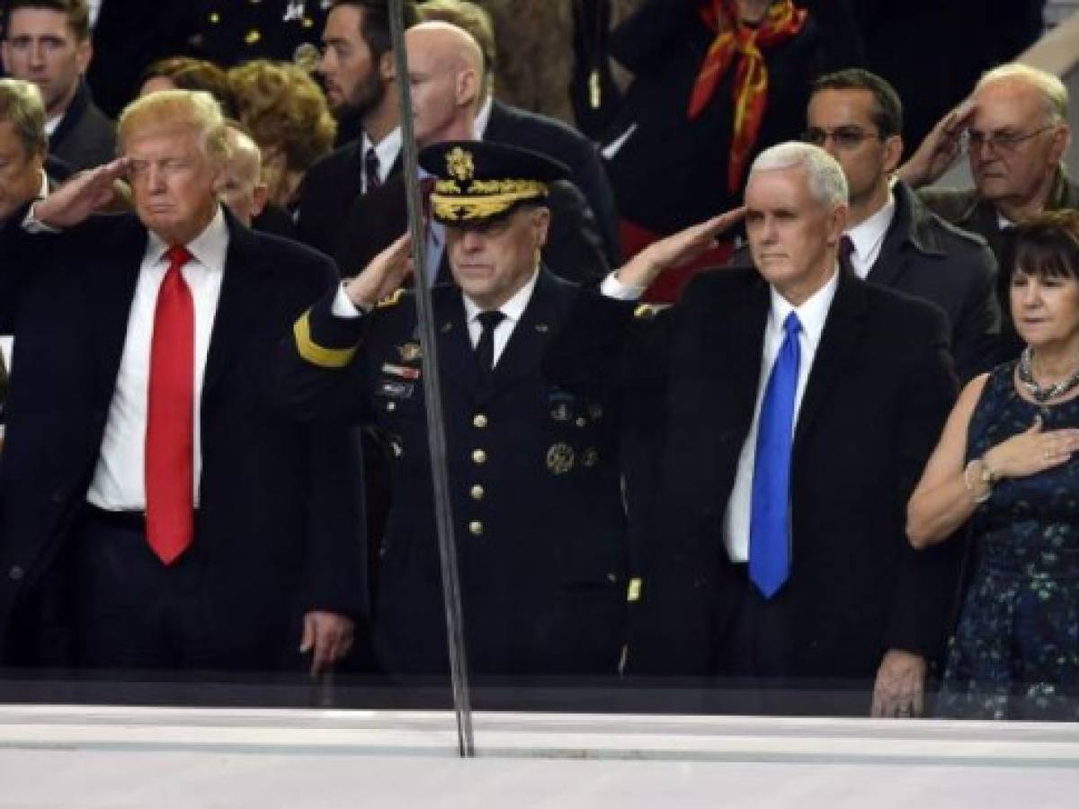 US President Donald Trump (L), Army General Mark Milley (C), Vice President Mike Pence (2nd R) salute during the presidential inaugural parade on January 20, 2017 in Washington, DC.At right is Karen Pence. / AFP PHOTO / Nicholas Kamm