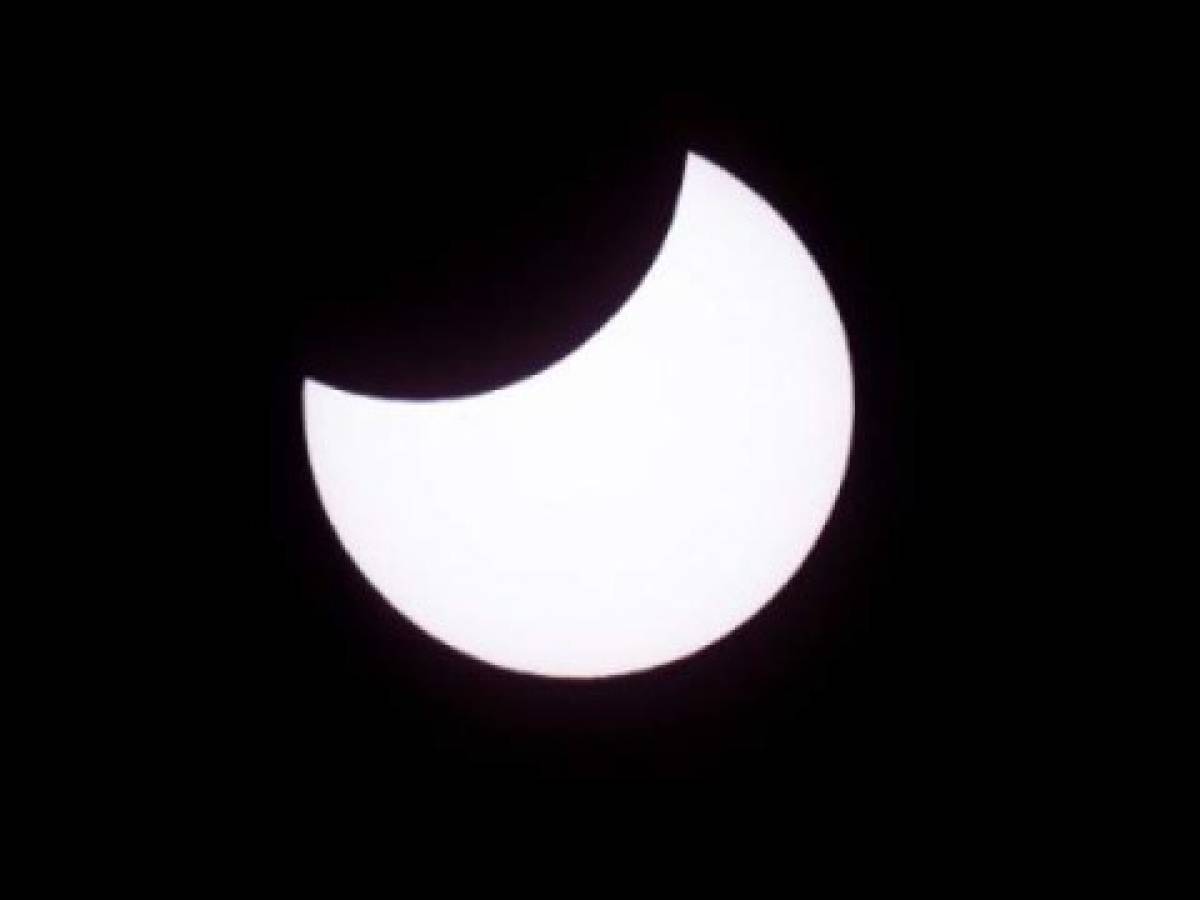 Picture taken on February 26, 2017 showing the moon moving to cover the sun for an annular solar eclipse, as seen from the Estancia El Muster, near Sarmiento, Chubut province, 1600 km south of Buenos Aires, Argentina, on February 26, 2017. Stargazers applauded as they were plunged into darkness Sunday when the moon passed in front of the sun in a spectacular 'ring of fire' eclipse. / AFP PHOTO / ALEJANDRO PAGNI