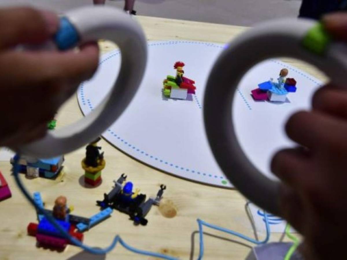 A fair worker presents the Toio toy playform at the booth of Sony at the IFA Consumer Electronics Fair in Berlin in Berlin on August 31, 2017.The fair is open for the public from September 1 to 6, 2017. / AFP PHOTO / TOBIAS SCHWARZ