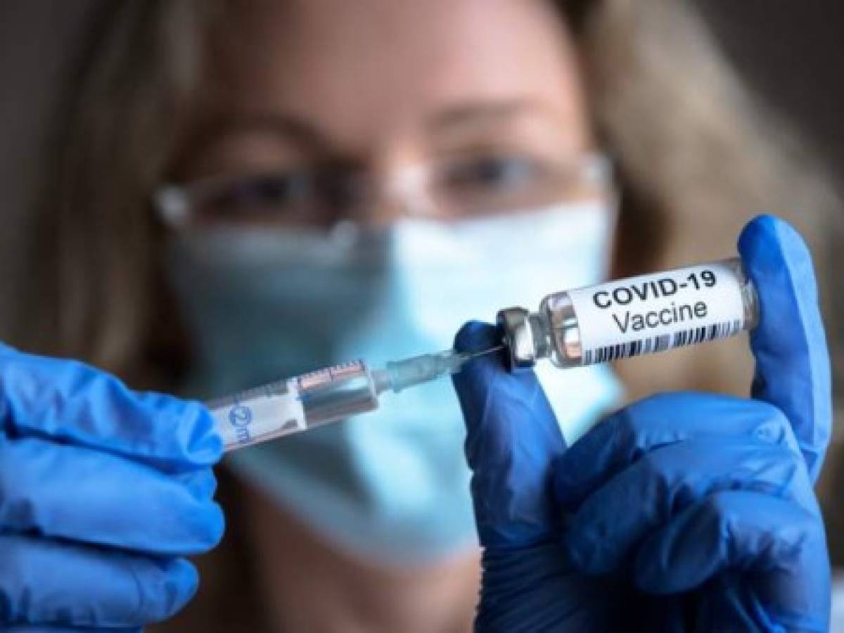 COVID-19 vaccine in researcher hands, female doctor holds syringe and bottle with vaccine for coronavirus cure. Concept of corona virus treatment, injection, shot and clinical trial during pandemic.