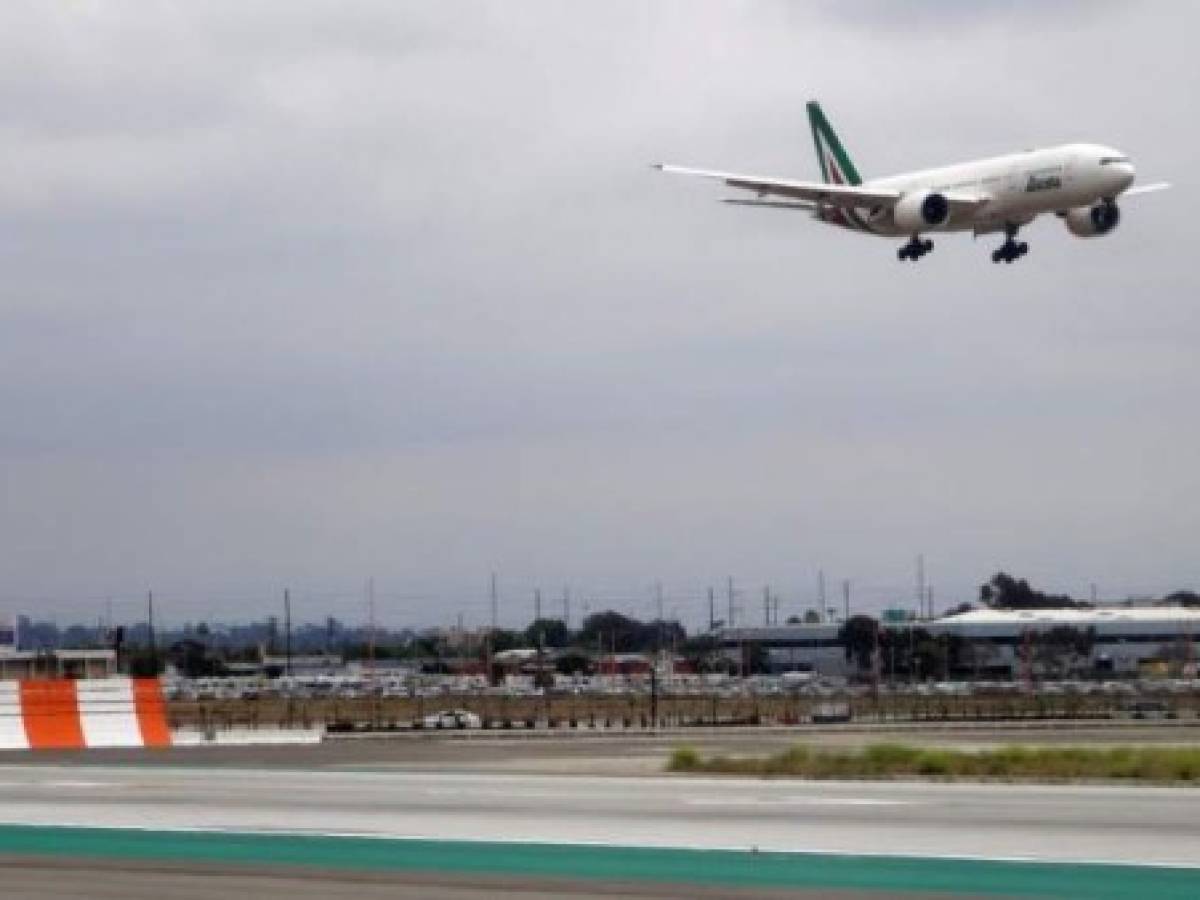 (FILES) In this file photo taken on May 24, 2018 an Alitalia Airplane lands at Los Angeles International Airport. - President Donald Trump announced on March 11, 2020 the United States would ban all travel from Europe for 30 days starting to stop the spread of the coronavirus outbreak. 'To keep new cases from entering our shores, we will be suspending all travel from Europe to the United States for the next 30 days. The new rules will go into effect Friday at midnight,' Trump said in an address to the nation. (Photo by Daniel SLIM / AFP)