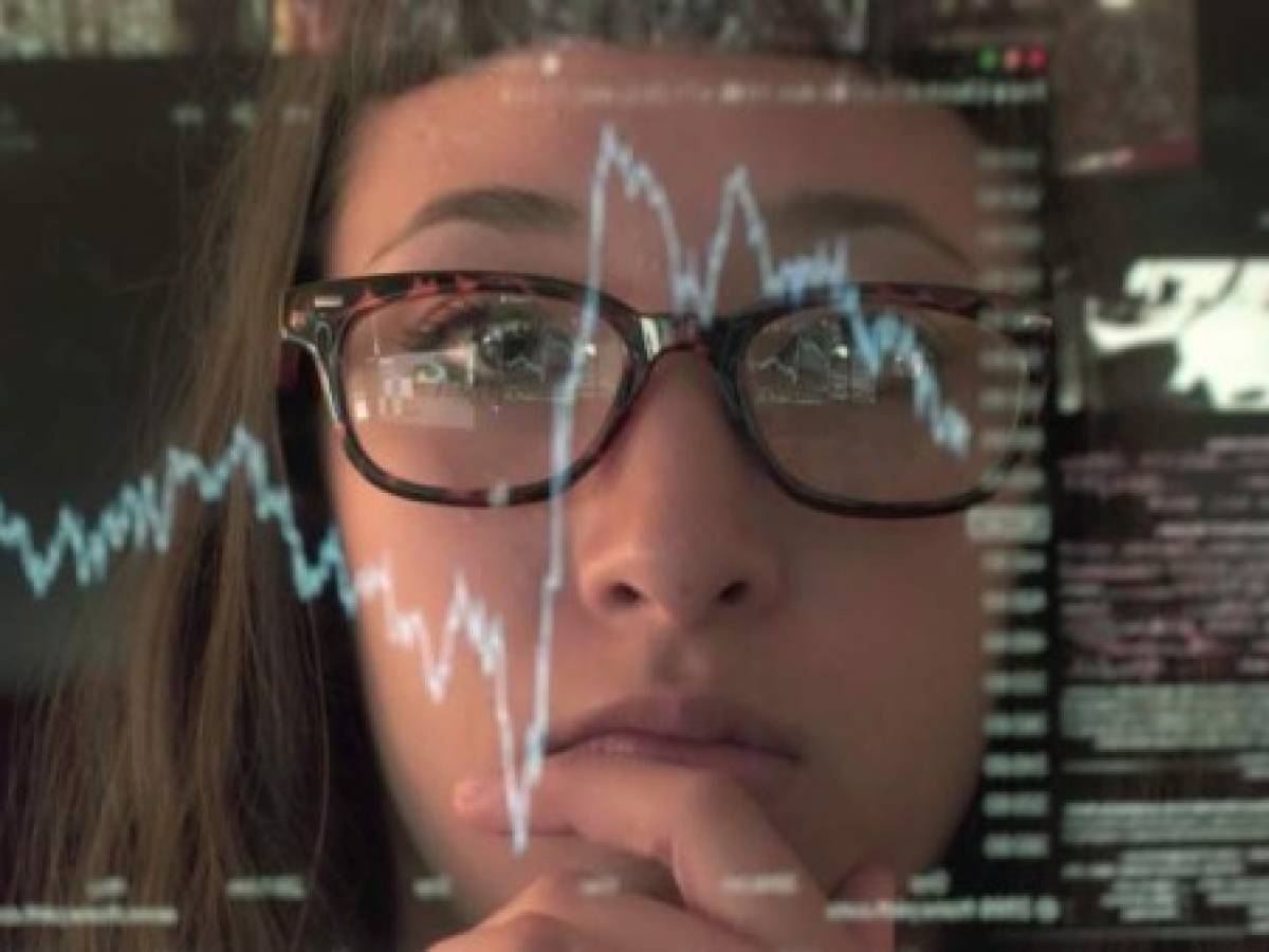 An asian woman concentrating on a touch screen display. The point of view is from behind the screen, looking through the data & images to the woman's face and hands as she manipulates the windows of information.