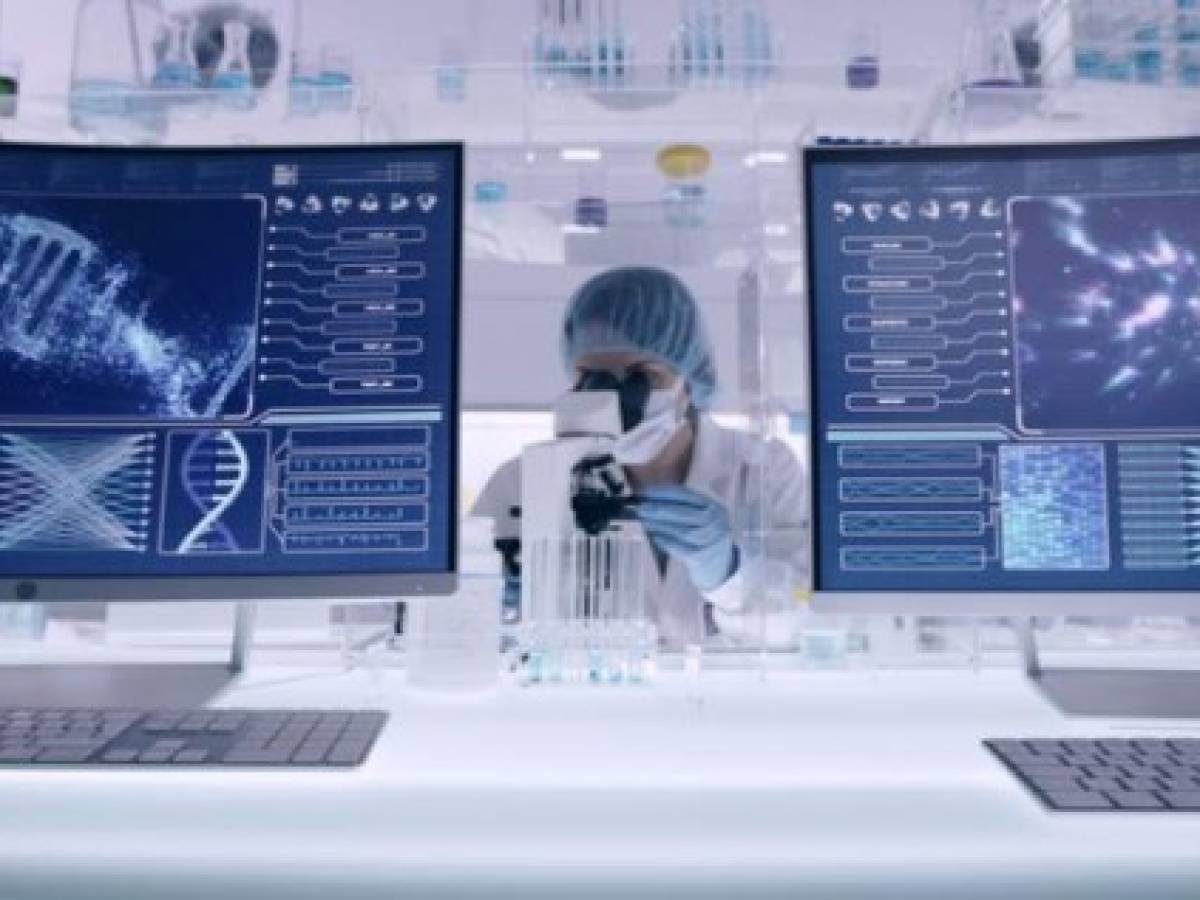 Scientist examines DNA models in modern Genetic Research Laboratory. Looking through laboratory glassware Scientist examines DNA models in modern Genetic Research Laboratory. Looking through laboratory glassware