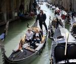 <i>Un gondolero navega con dos clientes cerca de la Plaza de San Marcos en Venecia, el 25 de abril de 2024. La nueva estrategia para reducir el número de turistas que visitan este lugar declarado Patrimonio de la Humanidad por la UNESCO exige que los excursionistas paguen un billete de cinco euros para entrar en el histórico centro de la ciudad y comenzará el 25 de abril. FOTO MARCO BERTORELLO/AFP</i>