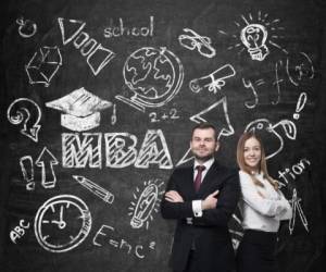 Young students are pondering over the business degree. A concept of the MBA degree. Drawn educational icons on the chalkboard.