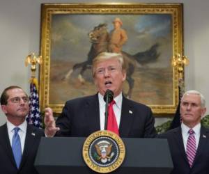 US President Donald Trump speaks during the swearing-in ceremony for Health and Human Services Secretary Alex Azar (L) as US Vice President Mike Pence (R) looks on in the Roosevelt Room of the White House on January 29, 2018 in Washington, DC. / AFP PHOTO / Mandel NGAN