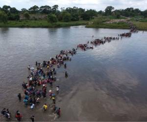 -- AFP PICTURES OF THE YEAR 2018 --Aerial view of Salvadorean migrants heading in a caravan to the US, crossing the Suchiate River to Mexico, from Ciudad Tecun Uman, Guatemala, on November 02, 2018. - According to the Salvadorean General Migration Directorate (DGME), over 1,700 Salvadoreans left the country in two caravans and entered Guatemala Wednesday, in an attempt to reach the US. (Photo by Carlos ALONZO / AFP)