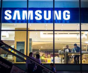 Bangkok, Thailand - November 1, 2012: Exterior view of a Samsung shop in the Siam Square area of Bangkok at night. people can be seen inside the store and making their way up an escalator outside. Image captured from the public walkway.