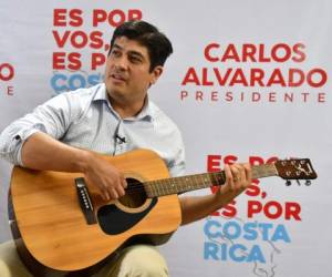 El candidato presidencial de Costa Rica, Carlos Alvarado, toca su guitarra en un Facebook Live que realizó el 29 de marzo de 2018. AFP PHOTO / Ezequiel BECERRA