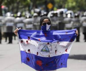 A demonstrator shows a bloody flag during a protest against Nicaraguan President Daniel Ortega's government in Managua, on September 16, 2018. / AFP PHOTO / INTI OCON