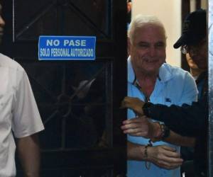 Panamanian former president (2009-2014) Ricardo Martinelli (C) is escorted during his arrival at the Supreme Court of Justice in Panama City on June 11, 2018 after he was extradited from the United States to face charges on spying on journalists and political opponents. Martinelli, 66, is accused of spying on the telephone calls of more than 150 people, including journalists and politicians. He is under investigation in Panama in about 20 other cases of corruption, but those are not referred to in the extradition request. Under a 1905 extradition treaty, he can only be tried in Panama for the crimes alleged in the request. / AFP PHOTO / STR