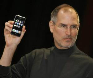 Apple chief executive Steve Jobs unveils a new mobile phone that can also be used as a digital music player and a camera, a long-anticipated device dubbed an 'iPhone.' at the Macworld Conference 09 January 2007 in San Francisco, California. The 'iPhone' will be ultra-slim -- less than half-an-inch (1,3 centimeters) thick -- boasting a phone, Internet capability and an MP3 player as well as featuring a two megapixel digital camera, Jobs said. / AFP PHOTO / TONY AVELAR