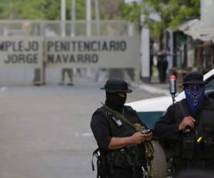 Prison guards stand by outside as relatives of political prisoners protest outside La Modelo maximum security prison in Tipitapa, near Managua on April 16, 2019, after a riot. - An opposition detainee died Thursday after a riot inside the maximum security prison which left at least six guards injured, the Ministry of the Interior said. (Photo by INTI OCON / AFP)
