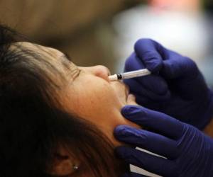 SAN FRANCISCO - DECEMBER 22: A woman receives an H1N1 flu nasal spray vaccination during a clinic at the Bill Graham Civic Auditorium December 22, 2009 in San Francisco, California. The city had 16,000 doses of the vaccine on hand for residents of the city. Justin Sullivan/Getty Images/AFP (Photo by JUSTIN SULLIVAN / GETTY IMAGES NORTH AMERICA / Getty Images via AFP)
